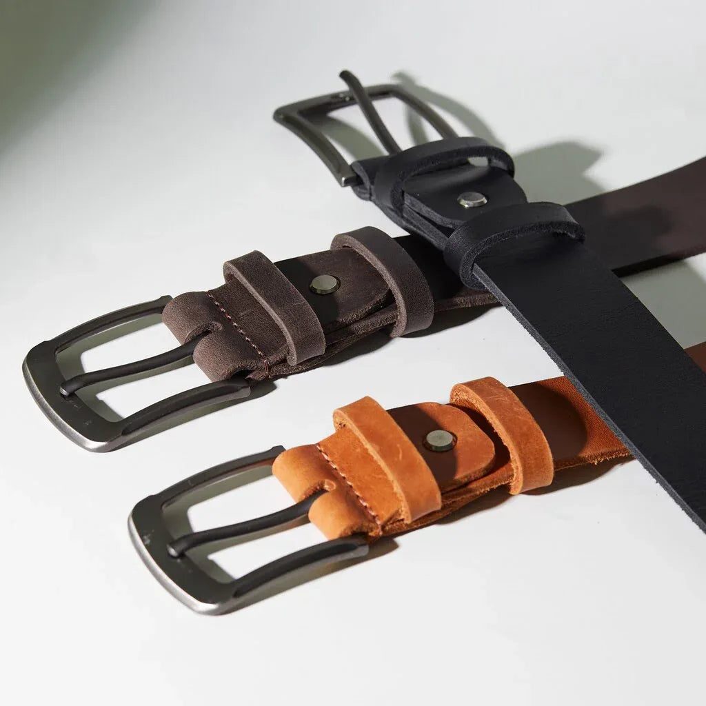 INCARNE leather belts in cognac, brown and black arranged on neutral background as a refined gift set
